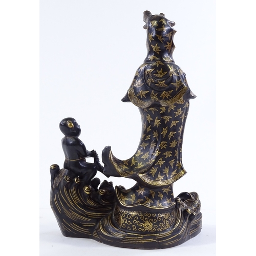 156 - A Chinese gilded and black glaze ceramic figure of Buddha, on wave design base, height 24cm