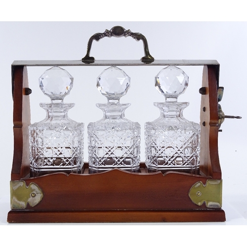 192 - A walnut and electroplate 3-bottle tantalus, length 33cm