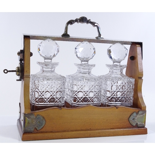 192 - A walnut and electroplate 3-bottle tantalus, length 33cm