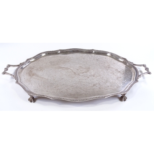 71 - A large silver plated oval tray, with beaded edge and claw and ball feet, length 72cm