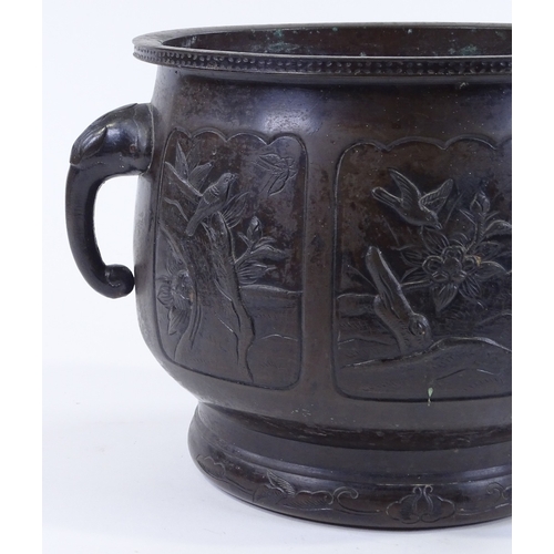 84 - A Chinese relief cast bronze 2-handled jardiniere, with shaped moulded panels depicting exotic birds... 