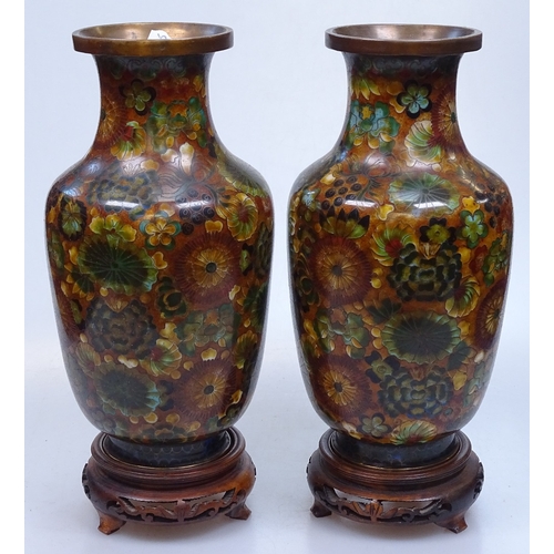 15 - A pair of Chinese floral decorated cloisonne enamel vases on wooden stands, height 10