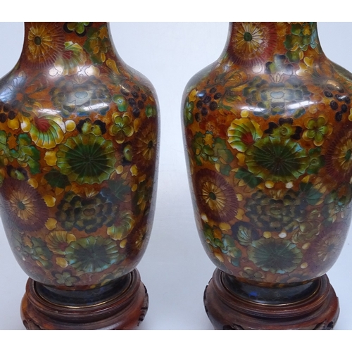 15 - A pair of Chinese floral decorated cloisonne enamel vases on wooden stands, height 10