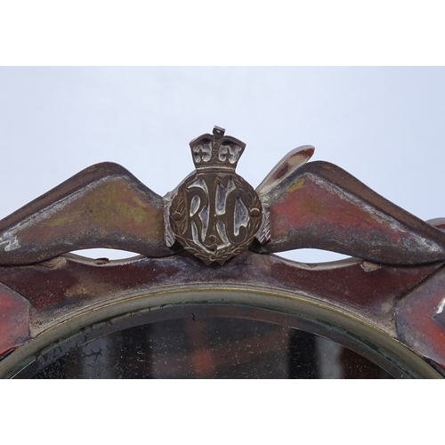 17 - A First War Period brass inlaid toilet mirror with RFC Wings mount, on Bakelite plinth, framed diame... 