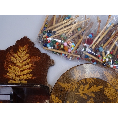 52 - A collection of lace maker's bobbins, and a Furnware wooden folding wall rack, and a Furnware plate