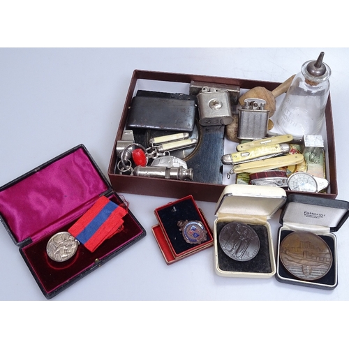 84 - A mixed box of items, including medallions, penknives, miniature frames, pocket lighters, a medal fo... 