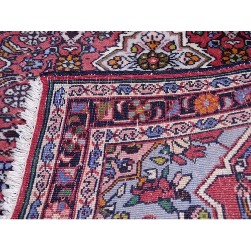 1832 - A red ground wool Persian style rug, 120cm x 80cm