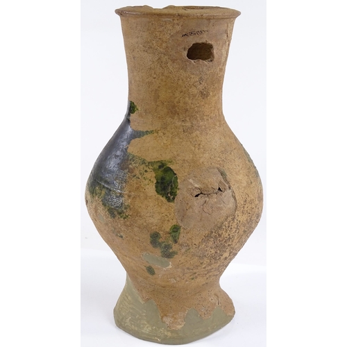 131 - A Medieval terracotta jug with parts of original green glaze A/F, height 31cm