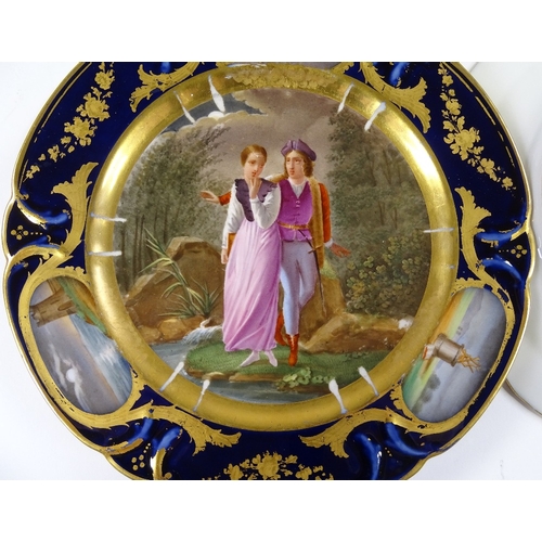 132 - A pair of 19th century Paris porcelain plates, with hand painted romantic panels in blue and gilt bo... 