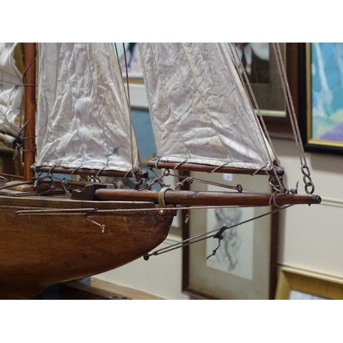 51 - A Victorian wooden-hulled pond yacht, with original sails and rigging, hull length 92cm, overall hei... 