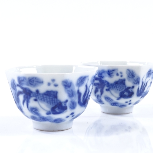 100 - A pair of Chinese blue and white porcelain tea bowls of octagonal form, with hand painted carp desig... 