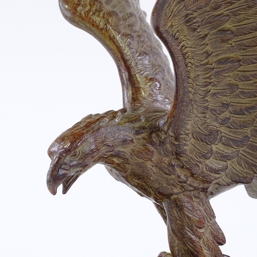 126 - An early 20th century patinated spelter sculpture of an eagle, unsigned, on black marble plinth, win... 