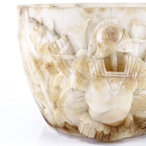 128 - An Antique high relief carved marble bowl section, decorated with Roman armour and weapons, possibly... 