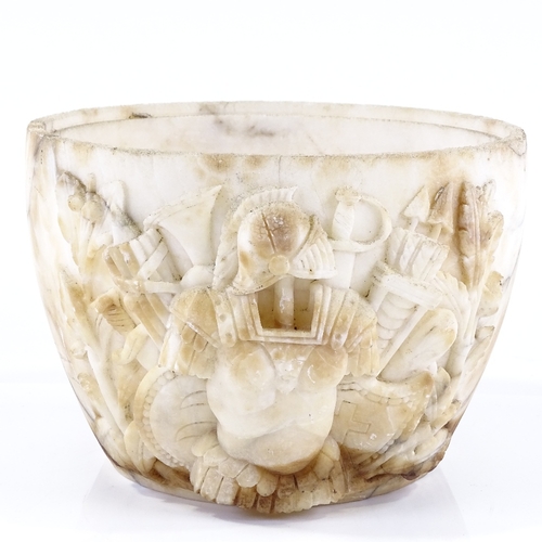 128 - An Antique high relief carved marble bowl section, decorated with Roman armour and weapons, possibly... 