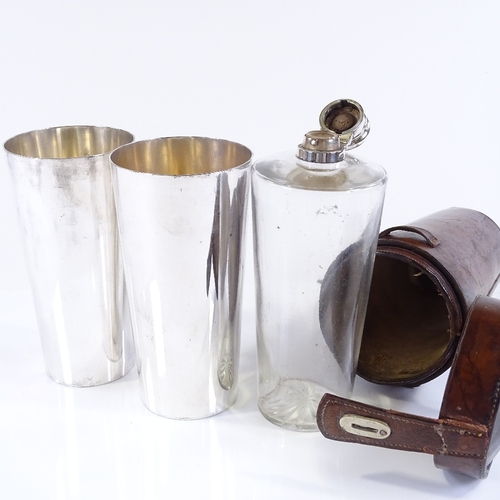 132 - A Victorian leather-cased travelling spirit bottle, and a pair of matching electroplate beakers, bea... 