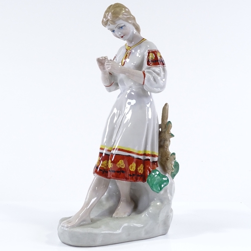 95 - A Russian porcelain figure of a girl holding a flower, height 29cm