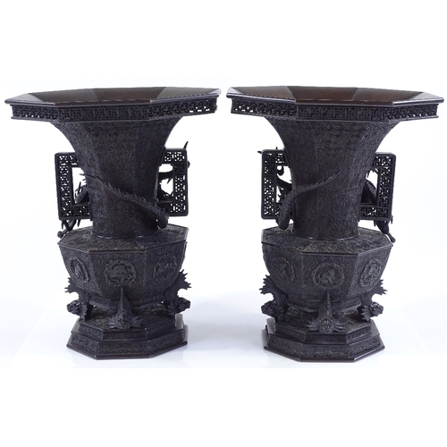 119 - A pair of Japanese Meiji period bronze vases, 3-dimensional dragon mounted necks, with pierced friez... 