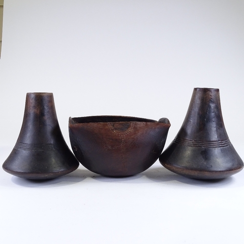 116 - A pair of African turned hardwood vases, height 24cm, and a similar carved wood bowl, length 26cm (3... 