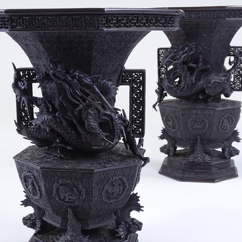 119 - A pair of Japanese Meiji period bronze vases, 3-dimensional dragon mounted necks, with pierced friez... 