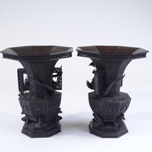 119 - A pair of Japanese Meiji period bronze vases, 3-dimensional dragon mounted necks, with pierced friez... 