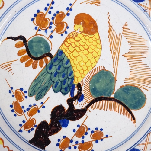 129 - An 18th/19th century Delft tin glazed ceramic plate with painted parrot design, diameter 22cm