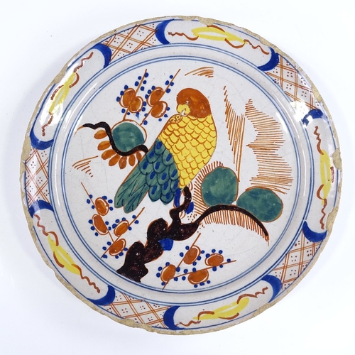 129 - An 18th/19th century Delft tin glazed ceramic plate with painted parrot design, diameter 22cm