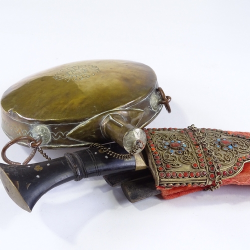 44 - An Eastern ornate kukri knife with coral and turquoise set filigree mounts, and an Eastern brass moo... 