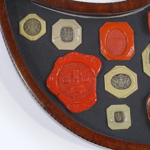 5 - A 19th century banded mahogany shield-shaped frame containing wax seals, width 41cm