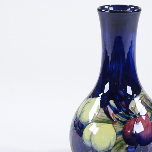 75 - A Moorcroft Pottery plum design blue ground narrow-neck vase, painted signature, height 23cm