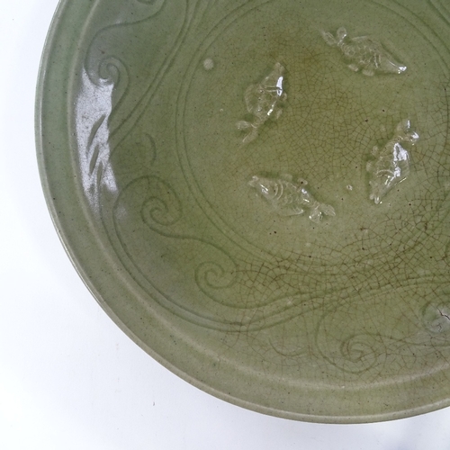 109 - A Chinese celadon green glaze porcelain table centre bowl, with relief fish designs, diameter 38cm