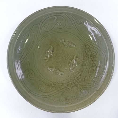 109 - A Chinese celadon green glaze porcelain table centre bowl, with relief fish designs, diameter 38cm