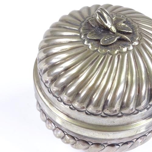 556 - A Continental circular silver lidded box, with fluted decoration and cast silver floral knop, silver... 