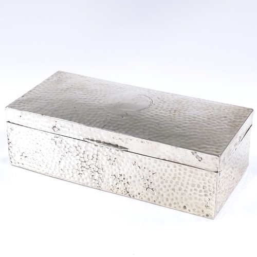 562 - An Edwardian rectangular silver cigarette box, with planished finish, by William Comyns & Sons, hall... 