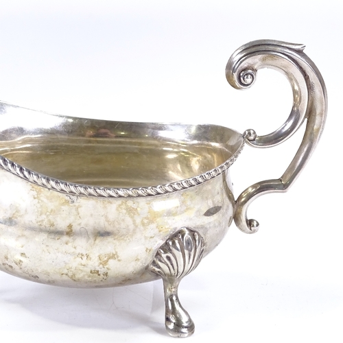 572 - A George V silver sauce boat, with gadrooned rim and foliate scrollwork handle, by Mappin & Webb, ha... 