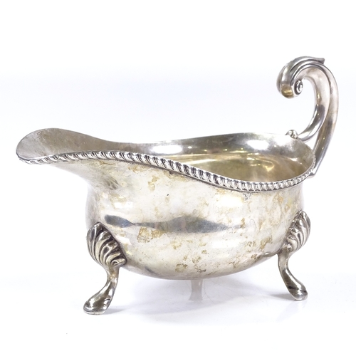 572 - A George V silver sauce boat, with gadrooned rim and foliate scrollwork handle, by Mappin & Webb, ha... 