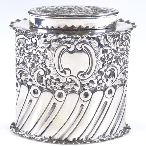 581 - A late Victorian oval silver tea caddy, of half-fluted form with relief embossed floral and scrollwo... 