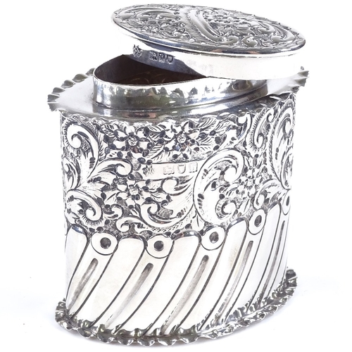 581 - A late Victorian oval silver tea caddy, of half-fluted form with relief embossed floral and scrollwo... 