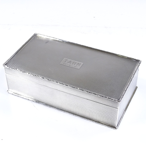 587 - A George V rectangular silver cigarette box, all over engine turned decoration with relief embossed ... 