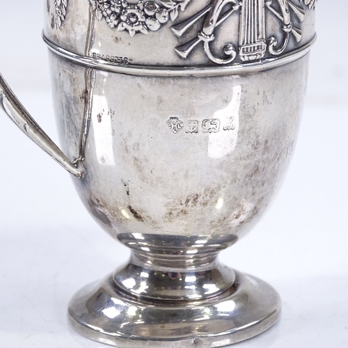 590 - An Edwardian silver helmet-shaped cream jug, with relief embossed Adams style decoration, and gilt i... 