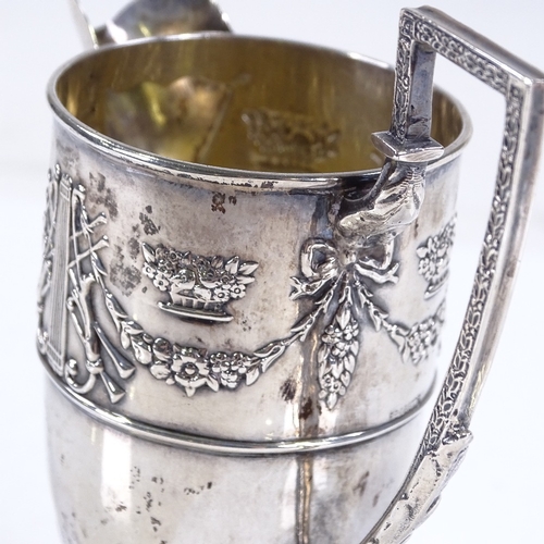 590 - An Edwardian silver helmet-shaped cream jug, with relief embossed Adams style decoration, and gilt i... 