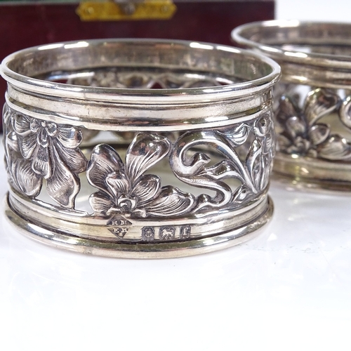 622 - A pair of Edwardian Art Nouveau silver napkin rings, with pierced floral decoration, 1 by Marples & ... 