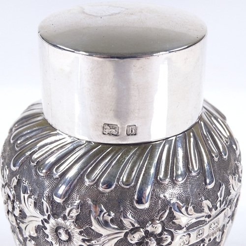 626 - An Art Nouveau circular silver tea caddy, of half-fluted form with relief embossed floral decoration... 