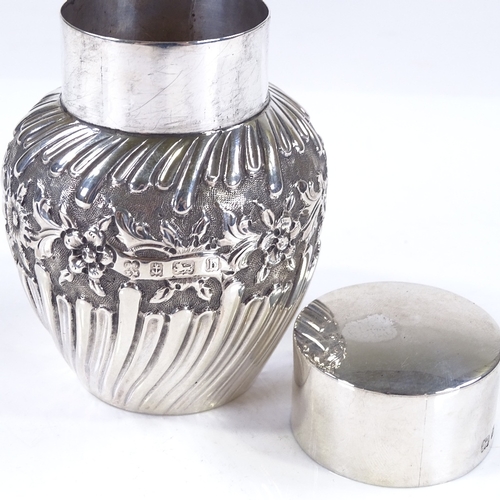 626 - An Art Nouveau circular silver tea caddy, of half-fluted form with relief embossed floral decoration... 