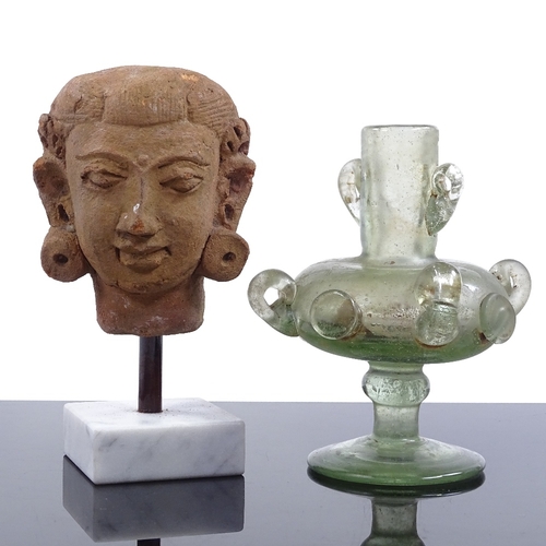 125 - An Indian Gupta terracotta head on stand, height 14cm, and an Islamic iridescent glass vessel (2)