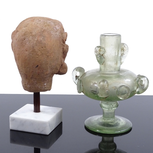 125 - An Indian Gupta terracotta head on stand, height 14cm, and an Islamic iridescent glass vessel (2)