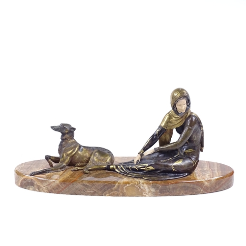 27 - An Art Deco style gilded and patinated spelter figure of a woman with a Borzoi dog, on onyx plinth b... 