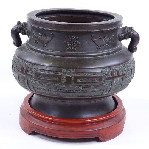 52 - A Chinese bronze incense burner, cast dragon design handles, with relief decorated frieze, rim diame... 