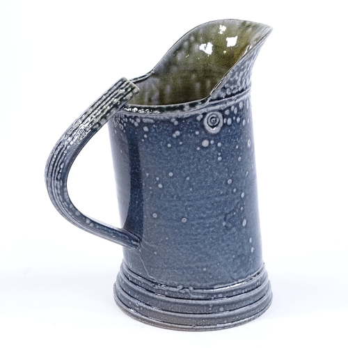 61 - Walter Keeler (British born 1942), a blue salt glaze leaning jug, height 17cm
