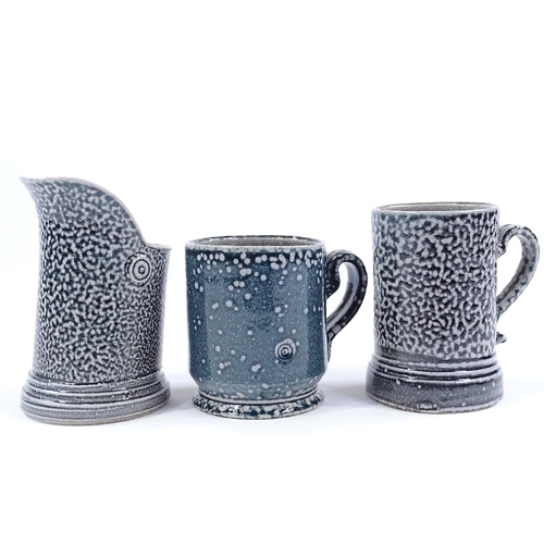 64 - Walter Keeler (British born 1942), a blue salt glaze leaning jug, height 12cm, and 2 salt glaze mugs... 