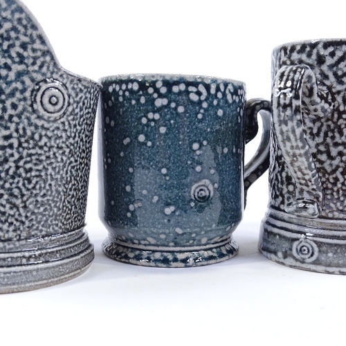 64 - Walter Keeler (British born 1942), a blue salt glaze leaning jug, height 12cm, and 2 salt glaze mugs... 